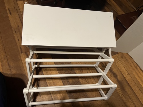 White wall retractable accordion drying rack with shelf.